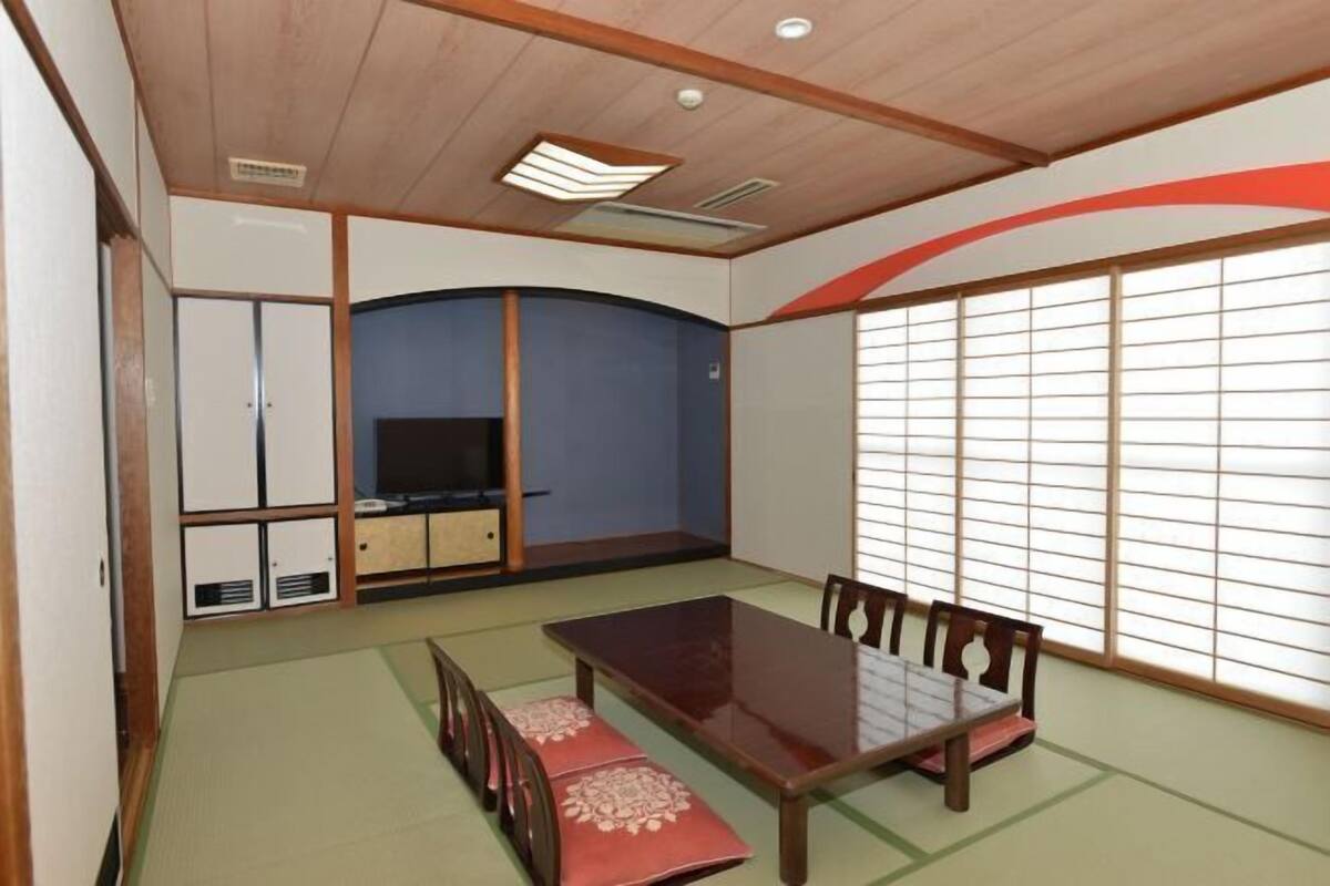 A traditional Japanese-style room with tatami flooring, a low wooden table, and sliding doors.