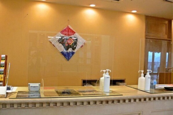 A reception area with a glass counter, a decorative wall hanging, and toiletries on the counter. - Yataro / Yataro Minamikan (Nagasaki City)