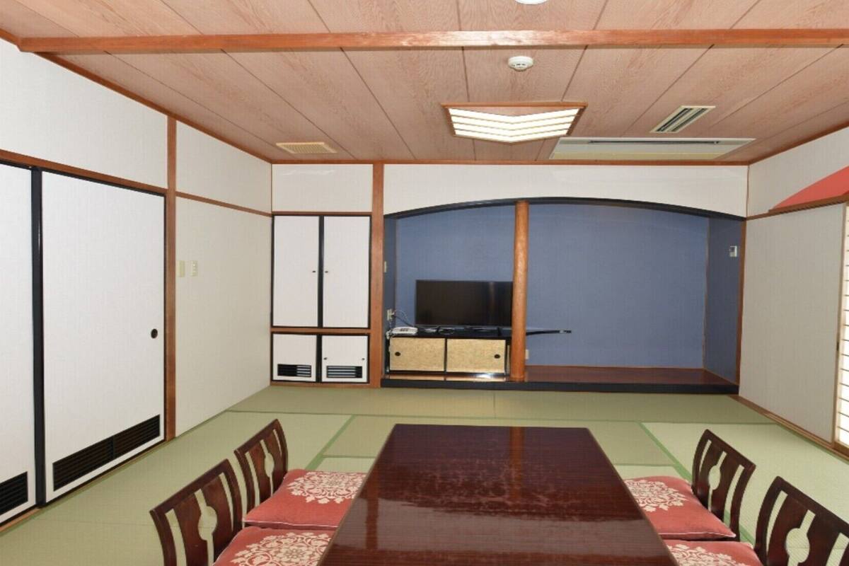 A traditional Japanese-style room with tatami flooring, a low table, and sliding doors.