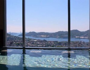 A view from a window overlooking a cityscape with a body of water and mountains. - Yataro / Yataro Minamikan (Nagasaki City)