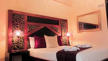 Relax in comfort with a large bed, bedside lamps, and a mirror above.