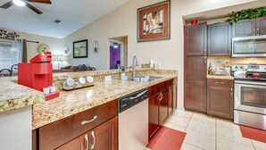 A modern kitchen with granite countertops, stainless steel appliances, and wooden cabinets.