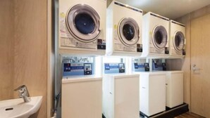 A laundry room with four washing machines and a sink. - Queens Hotel Chitose (Chitose)