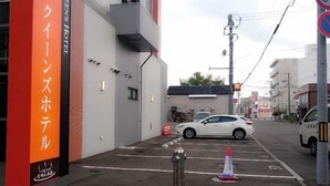 A parking area with a white car, a fire hydrant, and a traffic cone. - Queens Hotel Chitose (Chitose)