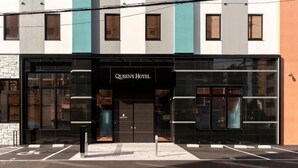 A hotel with a modern facade, large windows, and a prominent entrance. - Queens Hotel Chitose (Chitose)