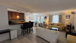 A compact living space with a kitchenette, a dining area, and a seating area with a sofa and chairs. - Best Kept Atlantic Ave Secret. Fab Location (Delray Beach)