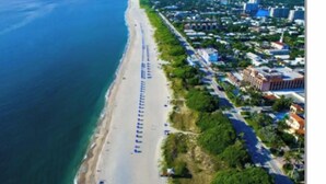 An aerial view of a coastal city with a long beach, dense urban area, and clear blue waters. - Best Kept Atlantic Ave Secret. Fab Location (Delray Beach)