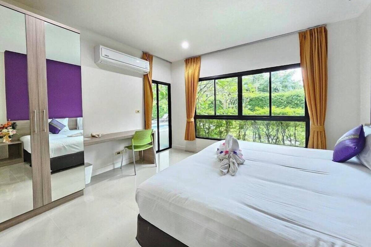 Un dormitorio con cama, una silla, un armario y ventana con vistas.