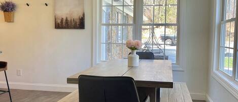 A dining area with a wooden table, black chairs, and a chandelier.