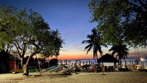 A beach with boats, a hut, and palm trees. - Kayaking, sailing, snorkeling Free w/ Cottage (Key Largo)