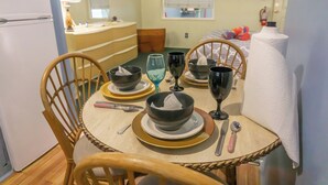A dining area with a round table set for four, including bowls, wine glasses, and cutlery. - Free sailing, kayaking, water toys etc w/ Cottage (Key Largo)