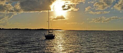 A sailboat on calm water during sunset.