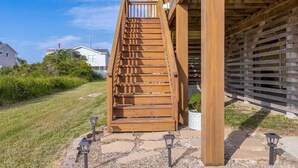 Una escalera de madera que lleva a un edificio con techo inclinado.