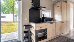 Una cucina moderna con forno integrato, macchina per caffè e cappa aspirante nera.
