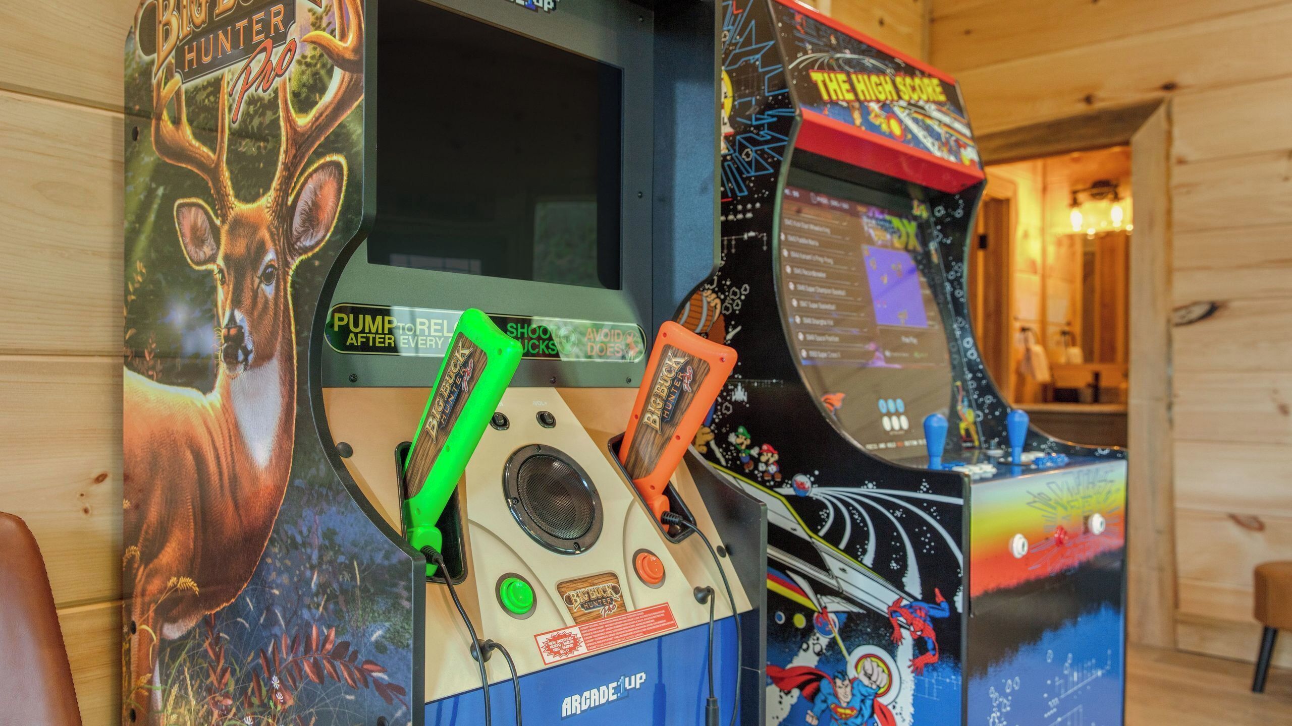Arcade machines with 'Big Buck Hunter' and 'The High Score' labels, a green joystick, and a speaker.