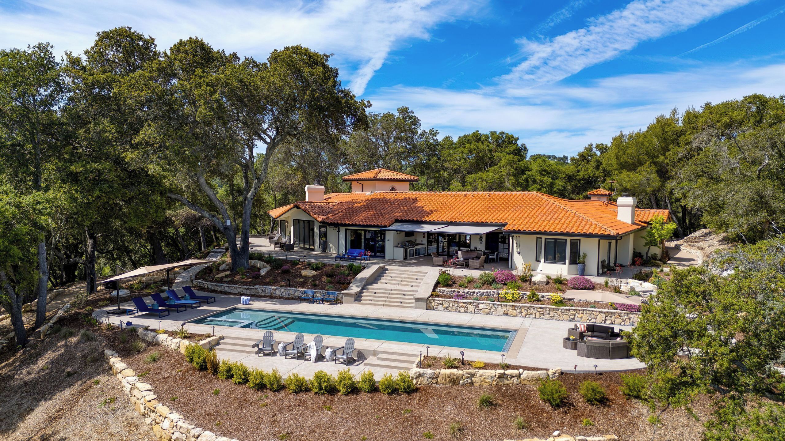Une maison avec une piscine, un espace extérieur aménagé et un jardin.