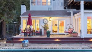 A house with a patio, outdoor seating, a clock, and a hanging chair. - A-lister by Avantstay Hollywood Hills Luxe Group Escape w/ Pool (Los Angeles)
