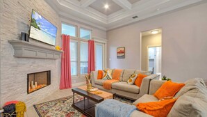 A living room with a fireplace, a sofa set, a coffee table, and a television mounted on the wall. - Graford by Avantstay Hot Tub, Firepit, Mini Putt (Corpus Christi)