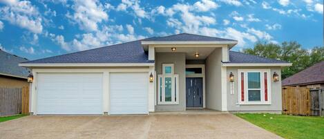 A two-story house with a garage, a front door, and a small porch area.