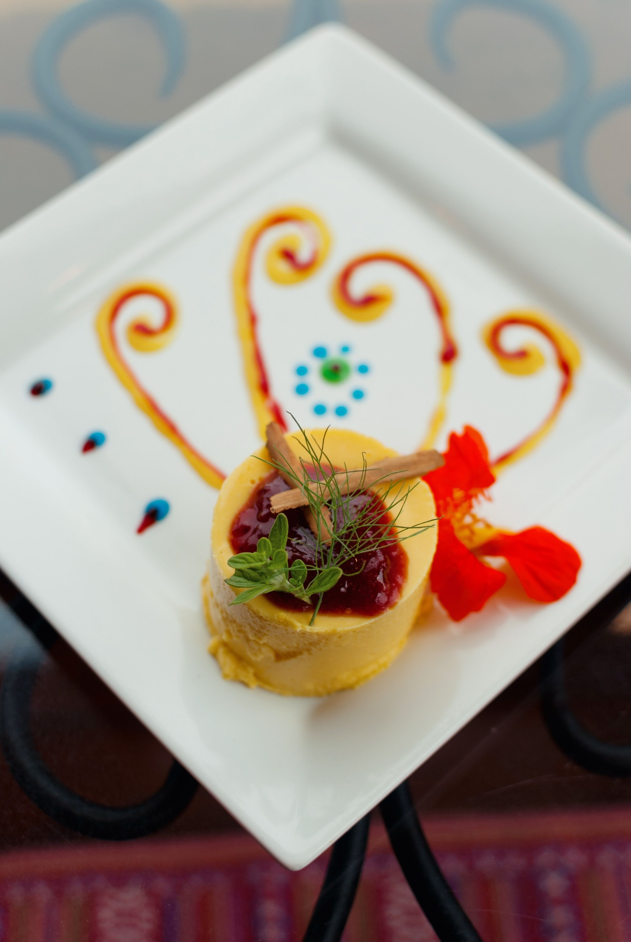 A square white plate with a dessert on a table.