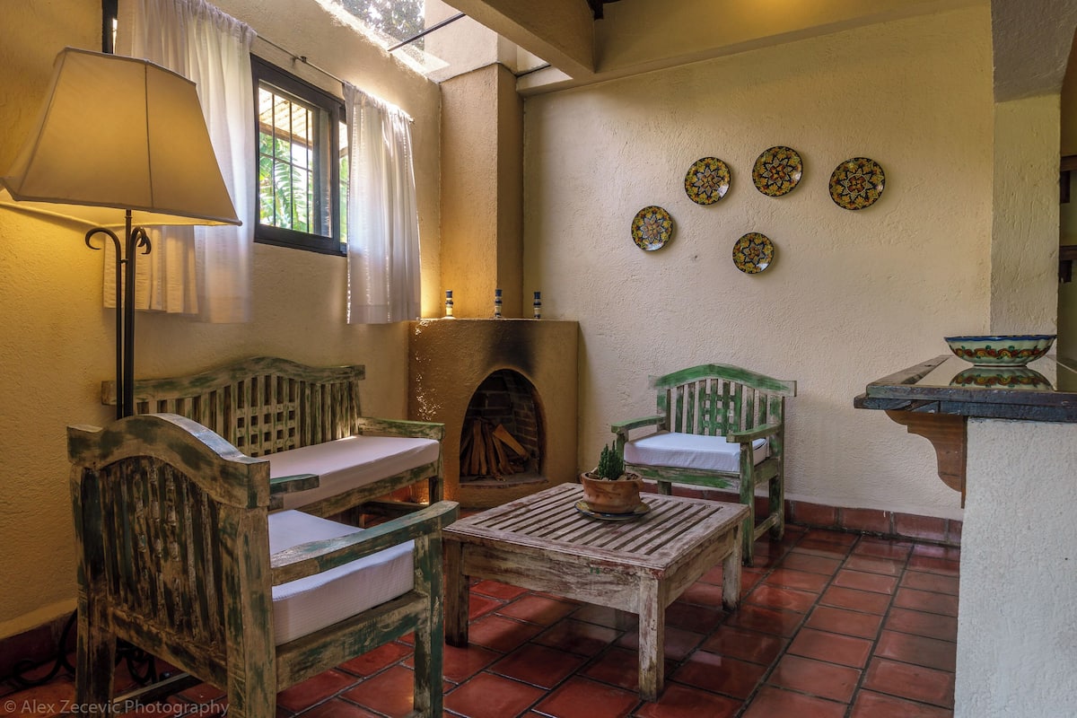 Un interior rústico con muebles de madera, una chimenea y platos decorativos en la pared.