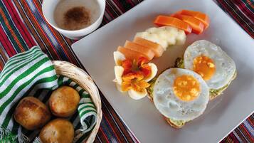 A plate with eggs, avocado, and sliced carrots.
