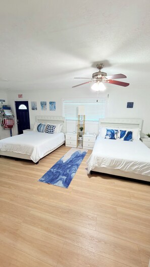 A hotel room with two beds, a ceiling fan, a window with blinds, and a blue rug. - Entire House Climatized Pool Close to the Beach (Hollywood)