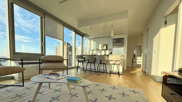 A modern apartment with a large living area, a kitchen, and a dining area. - 2 bed/2 bath luxe condo in Midtown  (New York)