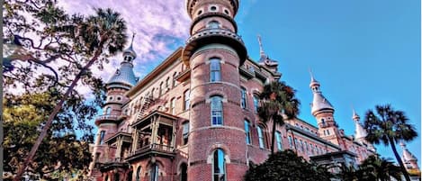 Un edificio grande e histórico con múltiples torres abovedadas y fachada de ladrillo.