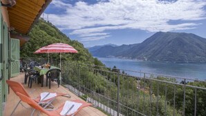 A balcony with chairs and a table, overlooking a lake and mountains. - MDS 3 - My Home in Como (Muronico)