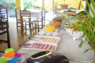 A buffet table with various food items and utensils.