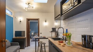 Une cuisine moderne dotée d’un îlot central, de tabourets de bar, d’une machine à café et offrant une vue sur l’espace de vie.