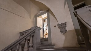 A grand staircase with ornate balusters and a dark floor, leading to a doorway. - Santo Spirito Frescoed 6 sleeps apartment (Firenze)