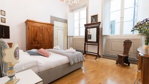 A bedroom with a bed, wooden wardrobe, dresser, and a mirror. - Santo Spirito Frescoed 6 sleeps apartment (Firenze)