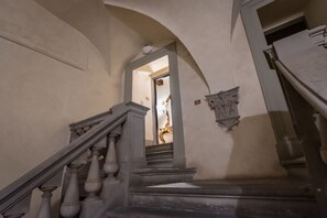 A grand staircase with ornate balusters and a handrail, leading to a doorway.