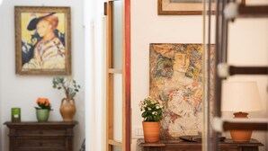 A room with a wooden dresser, a painting, and a potted plant. - Santo Spirito Frescoed 6 sleeps apartment (Firenze)