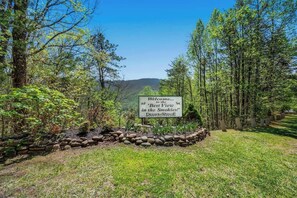 A welcome sign at Deer Ridge with a view of the Smokies.