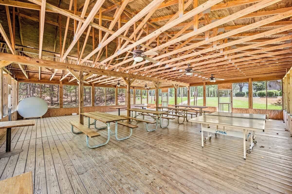 An indoor wooden pavilion with picnic tables and ceiling fans.