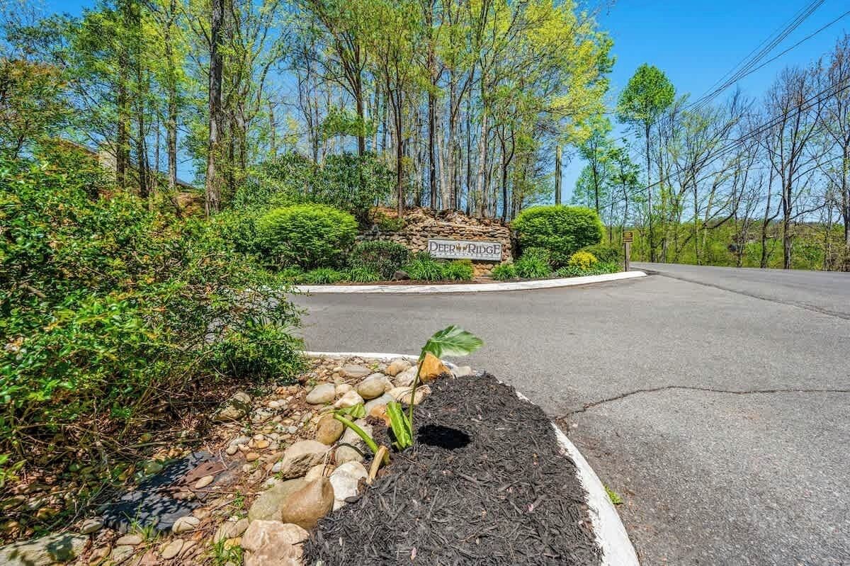 A road sign with "Deer Ridge" and a landscaped area with rocks and plants.
