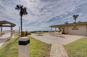 A fitness center with outdoor seating and a view of the ocean.