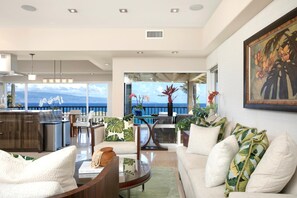 Un espacio habitable amplio con vista al océano, un comedor y una cocina.