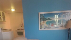 A living room with a beige sofa, a small table, and a painting on the wall. - BEYOND IMAGINATION (St. Thomas)