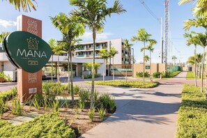 A modern hotel entrance with a sign reading "MANA BEACH EXPERIENCE" and a logo. - Flats Mana Beach Experience - Muro alto (Ipojuca)