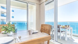 Ein Balkon mit einem Holztisch, Stühlen und einem Blumentopf.