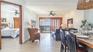 Une chambre d’hôtel avec un lit, un coin repas et une vue sur l’océan.