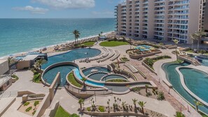 A resort with multiple swimming pools, a beach, and a high-rise building. - Las Palomas 2 BR 2 BA Diamante 601 (Puerto Peñasco)