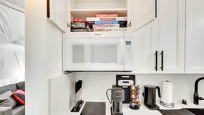A compact kitchenette with a microwave, coffee maker, and a small countertop. - 007 Geodome - Unique Escapes "007" Luxury Camping Geo-Dome! (Monticello)