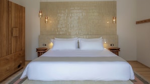 A large bed with white linens, a wooden headboard, and two bedside tables with lamps. - Hotel Casa Cuenca (Mexico City)
