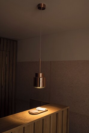 A modern kitchen with a wooden countertop, a hanging pendant light, and a wooden cabinet. - Hotel Casa Cuenca (Mexico City)