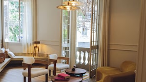 A cozy living room with a sofa, chairs, a coffee table, and a bookshelf. - Hotel Casa Cuenca (Mexico City)
